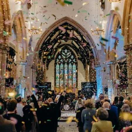 Band playing in a church with ticker tape falling down