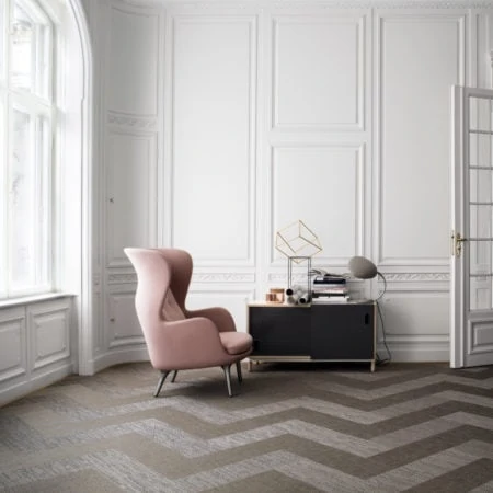 Stylish lounge with pink armchair and zig-zag carpet