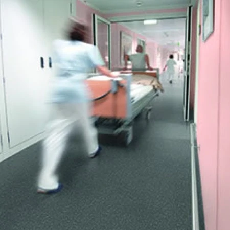 Hospital corridor with patient being wheeled through on stretcher