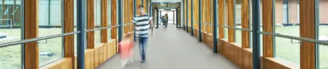 Parent and child walking through School corridor