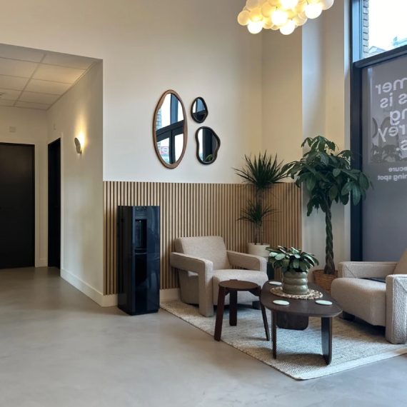 Stylish reception space with lounge seating, wood-panelled wall detail and natural light