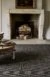 Traditional fire place with dark brown carpet and occasional table
