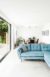 Polished concrete floor with blue sofa and large bi-fold doors